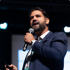 Palestrante de terno com microfone em um evento do programa